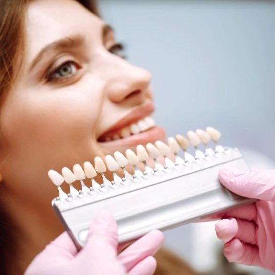 Patient looking at shade colors of teeth